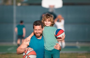 Baba ve oğlu basketbol oynuyor. Baba ve oğlu dışarıda basketbol oynuyorlar. Çocukluk ve ebeveynlik kavramı