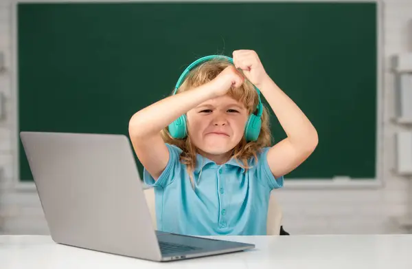 ラップトップコンピュータを使用して怒っている子供 オンラインEラーニングを通して勉強悲しい興奮した子供の男の子 ちょっと面白いシステム管理者 — ストック写真