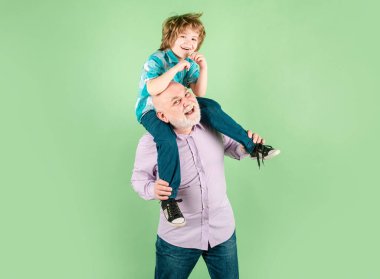 Komik yüzlü çocuk ve büyükbaba sırt üstü gezintiye çıkıyorlar. Yaşlı bir akraba ve çocuk.