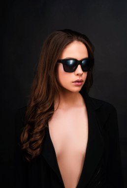 Moda sanatları stüdyosunda siyah gözlüklü zarif genç bir kadının portresi.