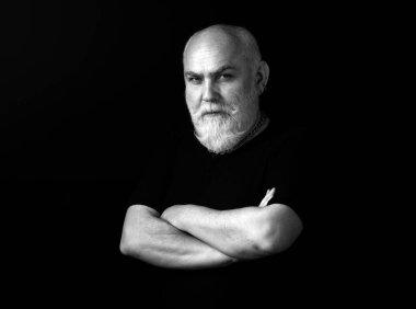 Sakallı, orta yaşlı bir adam yakın plan kafa ve omuz portresiyle ciddi bir ifade takınıyor. Ciddi kıdemli adam. Kameraya bakan yaşlı adamın sade stüdyo portresini kapat.