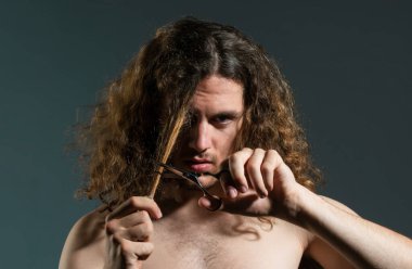 Genç seksi adam, berber makaslı adam portresi uzun saç kesimi. Modern berber dükkanı, tıraş. Modern saç stili siyah olan yakışıklı bir erkek.