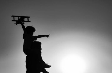 Baba 'nın gün batımında oğlunun omuzlarında taşıdığı siluet. Çocuk oğlu pilot ve baba babası uçakla