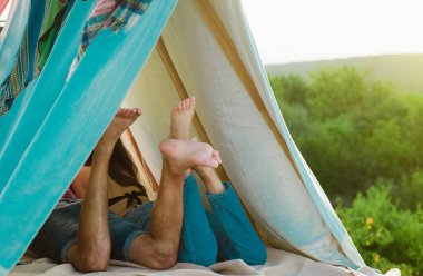Çadırda kamp yapan bir çift. Ayaklara odaklan. Birbirine aşık bir çift. Doğada romantik bir hafta sonu geçiren sevgili ve kız arkadaş. Birbirine aşık çiftlerin arka ayakları. Çadırda aşıklar