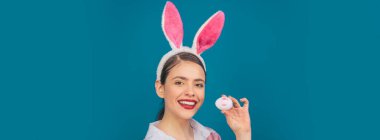 Tavşanlı Paskalya bayrağı. Mutlu Paskalyalar. Dudaklar ve Paskalya, Paskalya yumurtasında ruj izi. Tavşan kulaklı genç kadın. Tavşan kulaklı mutlu bir kadının portresi.