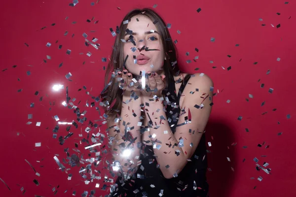 Sexy woman blowing confetti. Beautiful young woman on birthday, valentines day. Romance sexy woman blow sparkles on birthday. Woman celebrating birthday. Happy valentines day. Birthday party