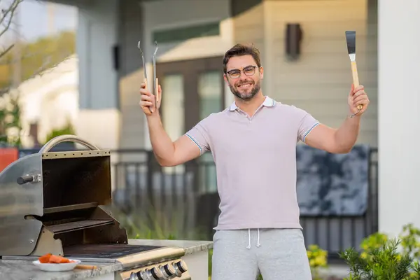 厨师准备烧烤 男厨师用烤肉烧烤烤肉 在房子的后院里 男人在烧烤上做饭 准备夏天的家庭晚餐 — 图库照片