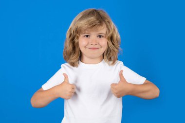 Stüdyoda izole edilmiş geçmişi olan bir çocuk. Çocuk portresi başparmak işareti yapıyor.