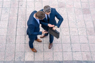 İş zamanı. En iyi iş görüşmeleri. İş adamı tecrübesini paylaşıyor. İş ortakları dışarıda buluşuyor. Formalite icabı giyinmiş iki kendine güvenen iş adamı bir şeyi tartışıyor.