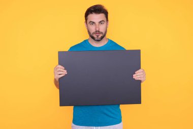 Bilgi konsepti. Boş pankartlı bir adam. Metnin ya da tasarımın için kopyalama alanı gösteriliyor. Stüdyo arka planında boş reklam panosu gösteren bir adam. Kopya alanı ve tabelalı boş pano
