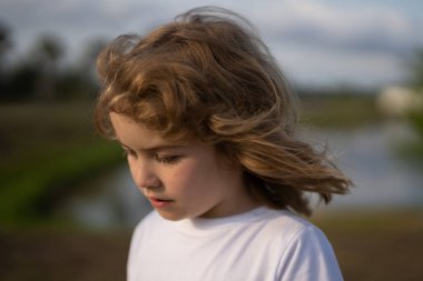 Oğlanlar yakın çekim, ciddi yüzler görür. Komik çocuk suratı yakın çekim. Çocuk portresi. Sarışın çocuğun yakın gözleri. Komik çocuk suratı. Sevimli bir çocuğun portresi. Açık havada çocuk portresi