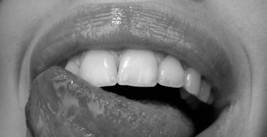 Güzel ağız ifadesi konsepti. Dudaklarını şehvetli bir dille yalayan kırmızı rujlu bir kadın yüzü.