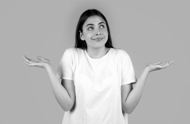 Güzel bir kadın ve sorgulama jesti. Kız omuz silkiyor, şüphe ediyor.