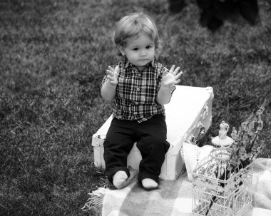 Doğada yeşil çimlerin üzerinde oynayan küçük bir bebek. Çocuklar oynuyor. Bebek ve yaz güneşli hava