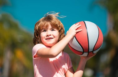 Basketbol oynayan bir çocuk. Basketbol topuyla poz veren bir çocuk