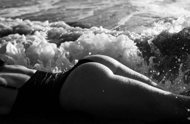 Summer butt of young girl with tanned sexy body. Firm buttocks in swimsuit bikini on beach