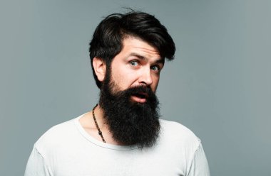 Şaşırmış yakışıklı sakallı adam. Erkek saç kesimi, modern saç stili. Uzun saçlı erkek modelin yakın portresi. Sağlık ve saç bakımı kavramı