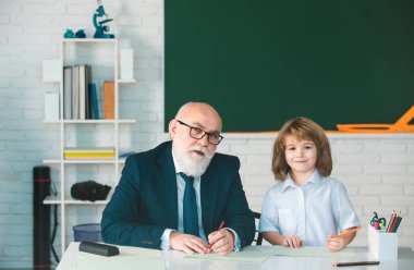 Okuldaki mutlu çocuk. Öğretmenin öğrenmesine yardım et. Eğitim, öğretmenlik, ilkokul