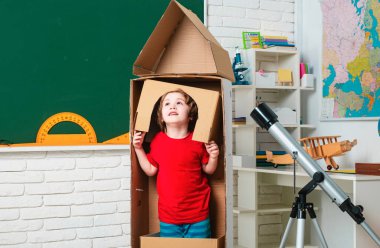 Astronot gibi giyinmiş, sınıfta oyuncak roketle oynayan, astronot olmayı hayal eden bir öğrenci. Çocukluk Geleceğin Rüyaları