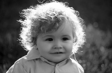 Çayır tarlasında küçük şirin bir bebek. Küçük çocuk dışarıda yürüyor, aile tatilleri. Bebek yüzü yakın plan. Komik küçük çocuk, yakın plan portre. Sarışın çocuk, gülümseyen duygusal yüz.