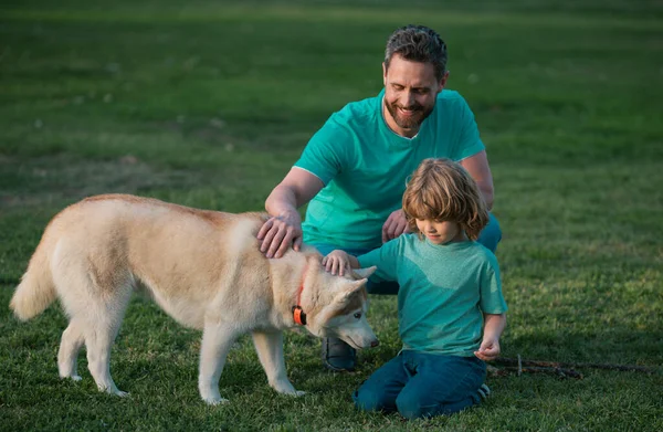 Father and son with dog in park