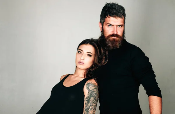 fashion couple. couple in love. brutal bearded man and woman with tattoo. hairdresser and barbershop. tattoo salon. male beard care. hipster man with sexy girl. relationship. serious emotions.