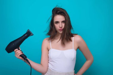 Woman with hair dryer in a studio