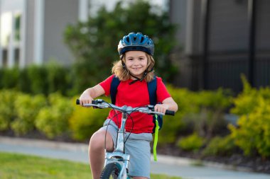Küçük çocuk parkta bisiklete biniyor. Bisikletli bir çocuk. Bisiklet süren kasklı mutlu çocuk. Çocuk bisiklete binmeye başladı. Bisikletli bir çocuk bisiklet sürüyor. Çocuk bisikleti