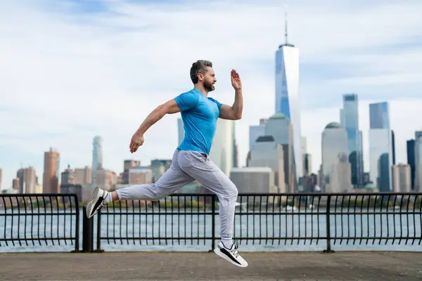 ニューヨークで開催されるスポーツ衣装のヒスパニックマンランナー 健全な走り ジョガーはダウンタウンのマンハッタンの近くで走る マッサージアスリートスポーツマンが市内を走る スポーツウェアを走る ワークアウトを実行しているハンサムな男 — ストック写真