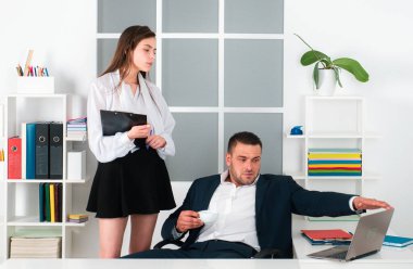 Genç seksi sekreter ve patron. Genç işadamı bayan patrona iş belgelerini gösteriyor.