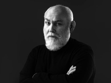 Yaşlı, yaşlı, olgun bir adam kıdemli adamın portresini yakından çekiyor. Siyah arka planda olgun bir adamın portresi