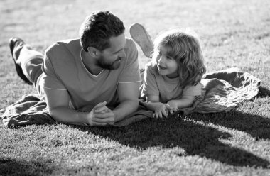 Mutlu baba ve oğul güneşli bir parkta tatilin tadını çıkarıyorlar. Aile kampı, tatil, babalar günü konsepti.