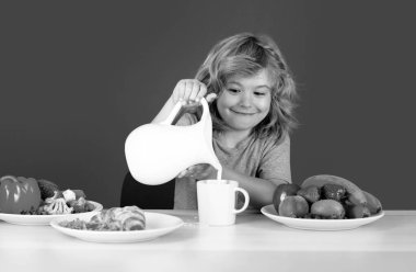 Mavi arka planda süt içen tatlı bir çocuk. Sütlü çocuk