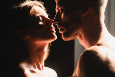 Hassas bir tutkuyla şehvetli bir çift. Birbirine aşık çiftler, şefkatle sarılıp öpüşüyorlar. Güzel kadın ve yakışıklı erkek arkadaş.