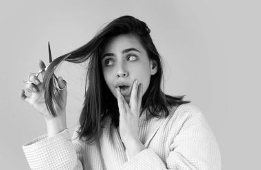 Sad woman having her hair cut with scissors. Beautiful woman in panic because of hair loss. Woman with hair loss problem