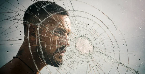砕いたガラスの後ろのマッチョな男 クラッシュテスト 感情的な排出 ガラスに弾丸の穴 ヒットのせいで割れたガラス セクシーなヒスパニックの男壊れた鏡 ガラスのひび割れ — ストック写真