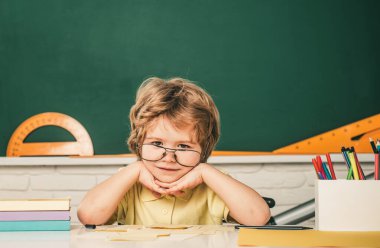 Öğrenci harf ve sayı öğreniyor. Çocuklar okula hazırlanıyor. Evde eğitim. Sınıfta, tahtaya yakın arkadaş canlısı bir çocuk. Yetenekli çocuk. Çocuk sınıfta tahtada öğreniyor.