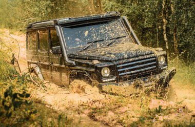 Gezgin off-road aracı. Lastikler yarışa hazırlanıyor. Yol macerası. Macera seyahati. Büyük 4x4 arabalı seyahat konsepti. Off-road aracı dağ yolunda gidiyor.