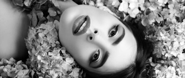 Woman beauty. Girl lying on flowers. Unity with nature. Blossom. Makeup cosmetics and skincare. Banner spring design, advertising for website header