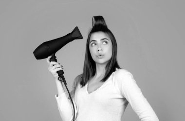 Saç kurutma makineli komik kadın. Düz saçlı, saç kurutma makinesi olan güzel bir kız. Saç stili, kuaförlük konsepti
