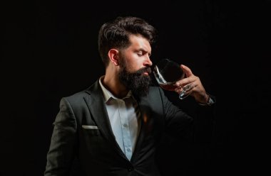 Zarif, zarif sakallı bir barmen viski bardağı tutuyor. Sommelier 'in pahalı bir içki tadı var.