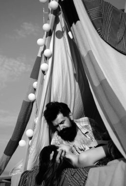 Bahar manzarasında kamp yapan romantik bir çift. Genç aşıklar için doğa çadırında bir macera. Kamp çadırında öpüşen hippi çift.