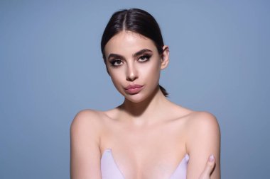 Youth and skin care concept. Photo of sensual model isolated on studio background. Close up portrait of beautiful woman with soft clean pure skin. Beauty face of young woman with red lipstick on lips