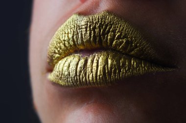 Altın dudaklı kadın yüzünü kapat. Ağzında altın boya var. Altın dudaklar. Lüks altın dudaklar makyaj. Yaratıcı metalik rujlu altın dudaklar. Altın metal dudak. Şehvetli kadın ağzı, sıkı tutun, makro