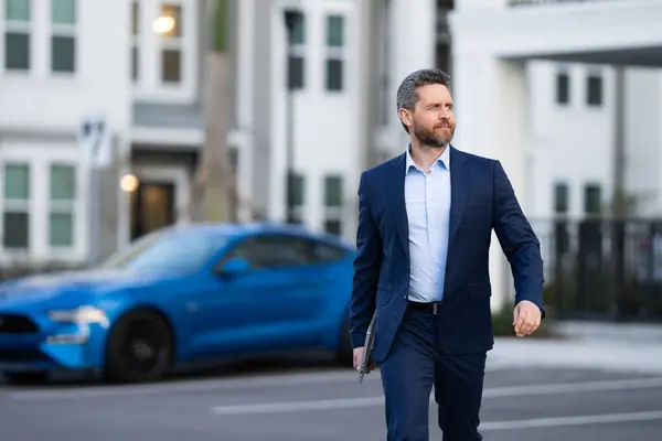 Businessman leaving office. Businessman walking home from work. Businessman working late. Businessman after success office work. End of business day. Successful business man in business suit outdoor