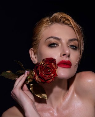 Kırmızı rujlu kırmızı dudaklar. Kırmızı dudaklı, güzel bir kadın ve stüdyoda poz veren güllerle makyaj yapan bir kadın. Güzellik ve moda portresi
