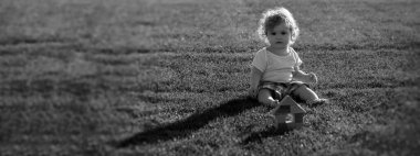 Banner with spring child face. Insurance kids. Baby play in green grass. Warm spring time in the park