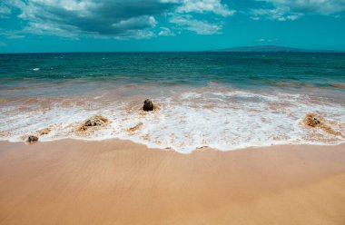 Kumlu sahilde mavi okyanus dalgası. Yaz mevsiminde gün batımında plaj. Plaj manzarası. Tropik deniz manzarası, sakinlik, dinlendirici güneş ışığı