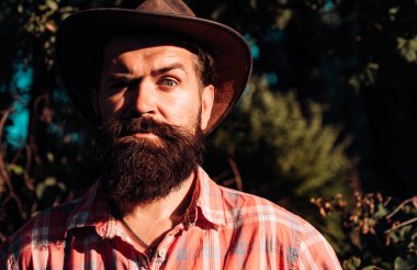 Kovboy şapkalı ciddi bir adamın yakın portresi.