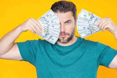 Sarı stüdyoda nakit para tutan zengin bir adam. Büyük şans, afiş. Dolar nakit para konsepti. Nakit para kazanmak için sevinir, şanslı para. Nakit parası olan bir adam. Finansal şans ve başarı